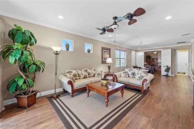 10641 Jackson Square Dr, Estero, FL 33928 - living area with crown molding, ceiling fan with notable chandelier, baseboards, visible vents, and wood finished floors