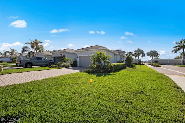 10641 Jackson Square Dr, Estero, FL 33928 - ranch-style house with stucco siding, a residential view, decorative driveway, a front lawn, and a garage