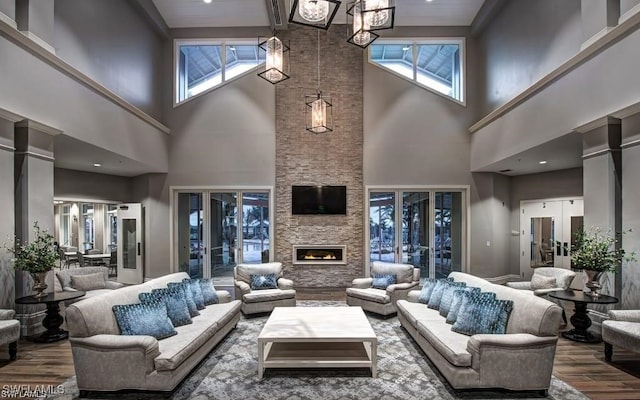 10641 Jackson Square Dr, Estero, FL 33928 - living room featuring an inviting chandelier, a stone fireplace, and wood finished floors