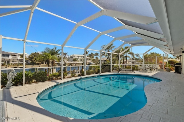 outdoor pool with a lanai, a water view, and a patio