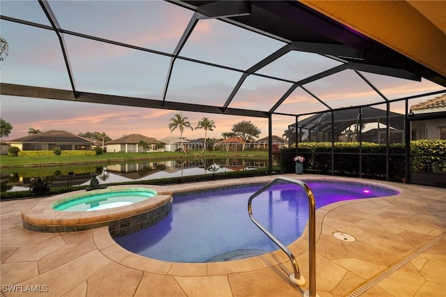 pool at dusk featuring a lanai, an in ground hot tub, a patio, and a water view