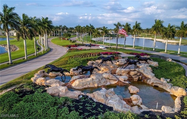 view of property's community with a yard and a water view