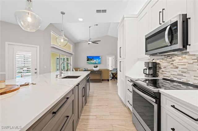 kitchen with white cabinetry, stainless steel appliances, sink, and pendant lighting