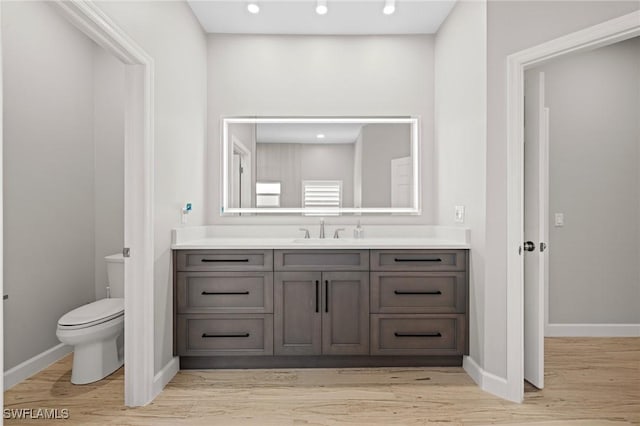 bathroom featuring vanity, hardwood / wood-style floors, and toilet