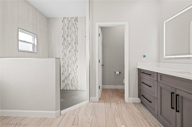 bathroom with a shower, vanity, and toilet