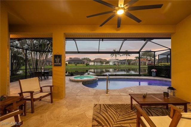 pool at dusk with a patio area, an in ground hot tub, glass enclosure, and a water view