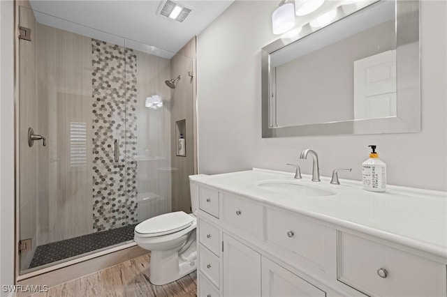 bathroom with vanity, hardwood / wood-style floors, an enclosed shower, and toilet