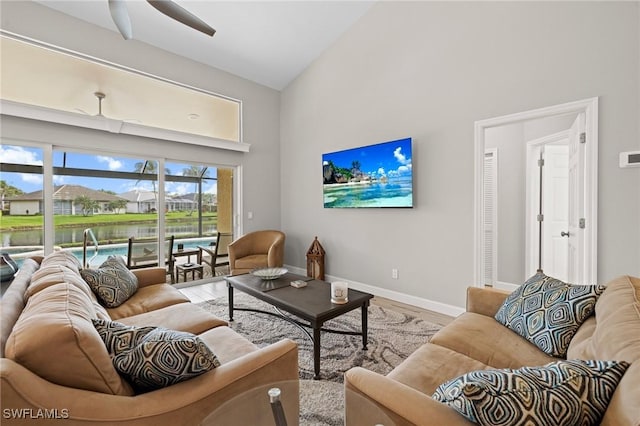 living room featuring hardwood / wood-style floors, high vaulted ceiling, and ceiling fan