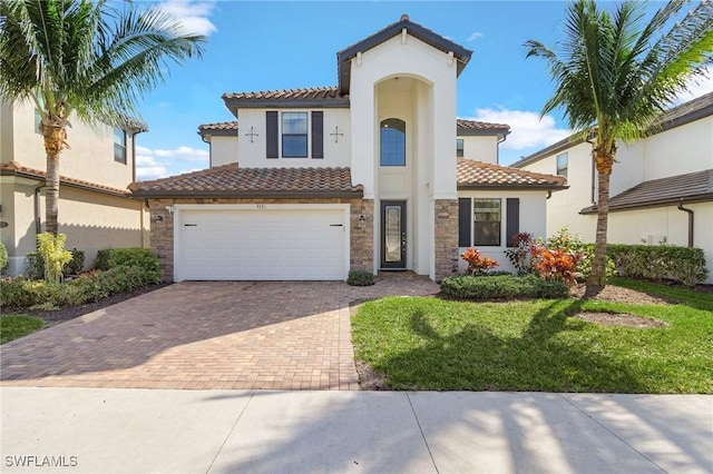 mediterranean / spanish-style house featuring a garage and a front lawn