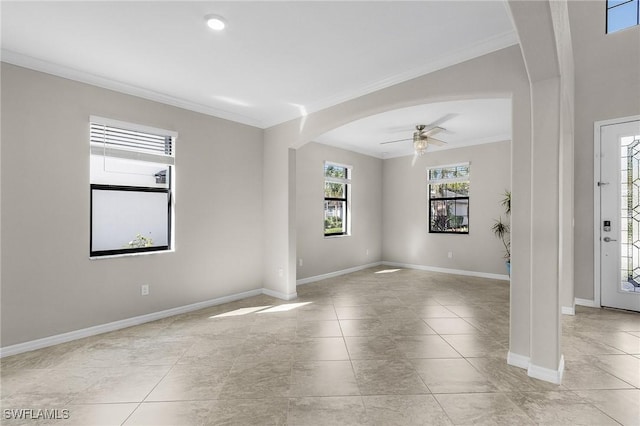 empty room with light tile patterned floors, ornamental molding, and ceiling fan