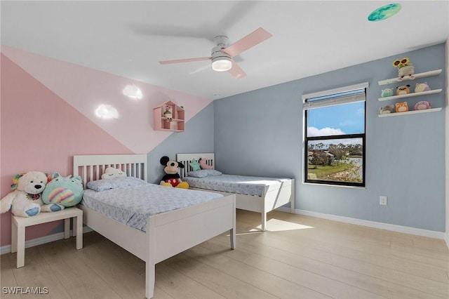 bedroom with ceiling fan, lofted ceiling, and light wood-type flooring