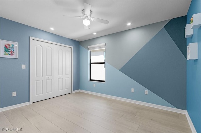 unfurnished bedroom featuring light hardwood / wood-style floors, a closet, and ceiling fan