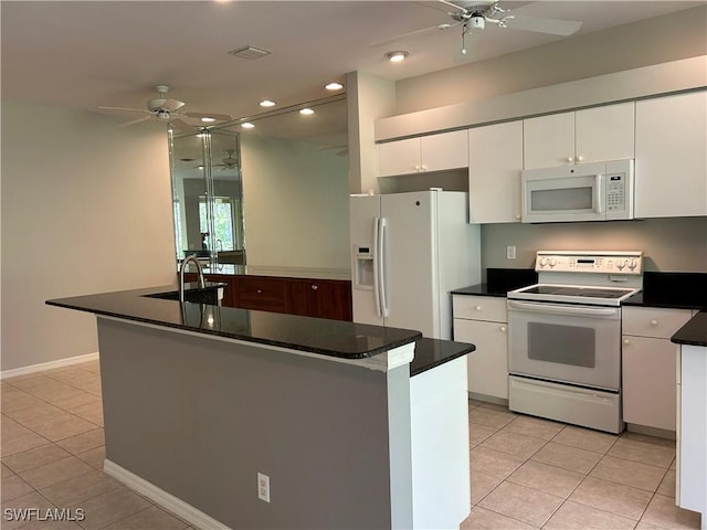 kitchen featuring light tile patterned floors, white appliances, a center island, and white cabinets