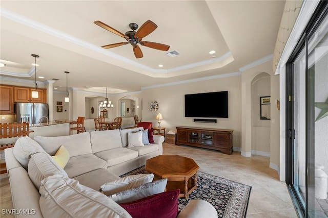 living room featuring crown molding, light tile patterned flooring, ceiling fan, and a tray ceiling