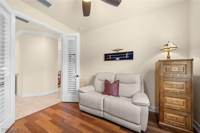 sitting room with dark wood-type flooring and ceiling fan