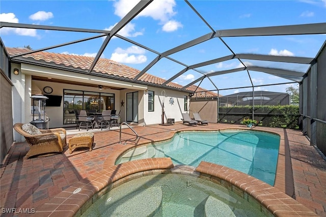 view of pool featuring a lanai, a patio area, and an in ground hot tub