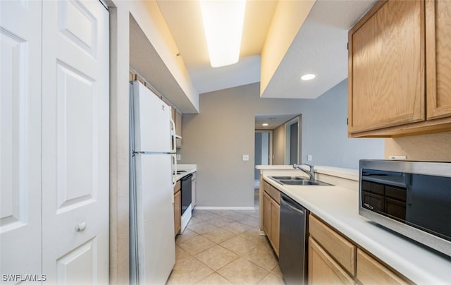 kitchen featuring light tile patterned floors, baseboards, appliances with stainless steel finishes, light countertops, and a sink