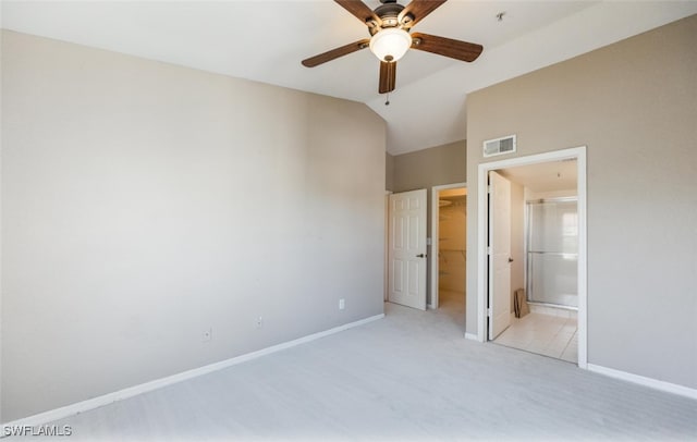 unfurnished bedroom featuring lofted ceiling, baseboards, visible vents, and a walk in closet