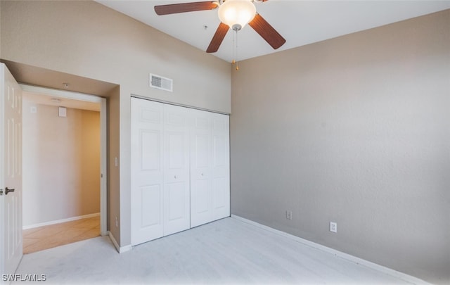 unfurnished bedroom featuring baseboards, visible vents, a ceiling fan, light colored carpet, and a closet