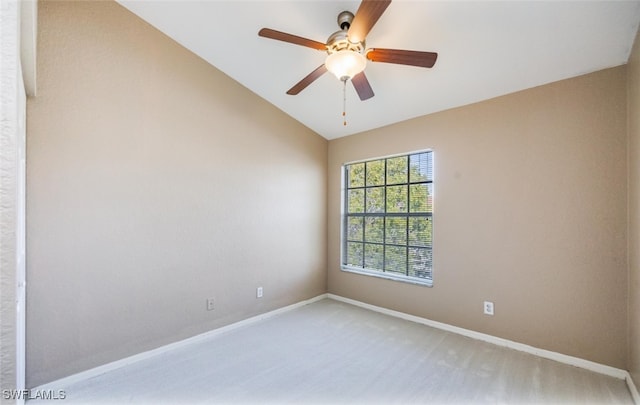 empty room featuring ceiling fan, baseboards, vaulted ceiling, and carpet flooring