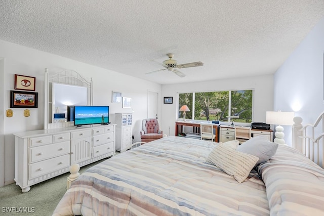 carpeted bedroom with ceiling fan and a textured ceiling