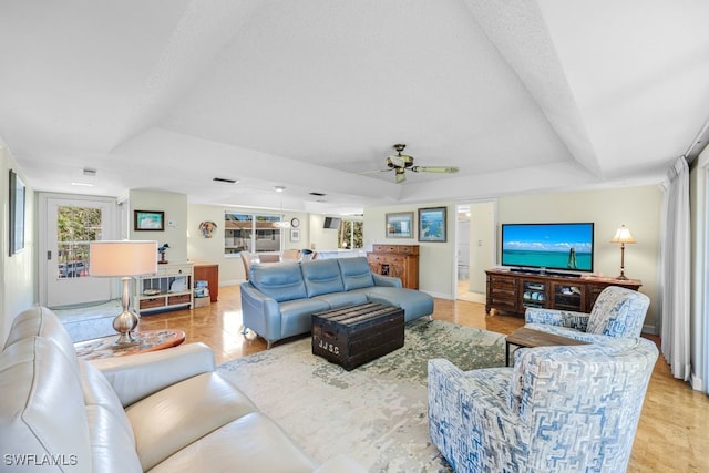 living room featuring a tray ceiling, a wealth of natural light, and ceiling fan