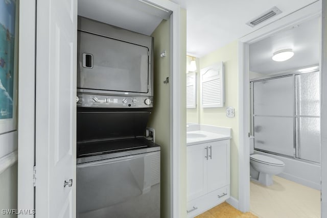 laundry area with stacked washing maching and dryer