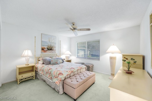 carpeted bedroom featuring ceiling fan and a textured ceiling