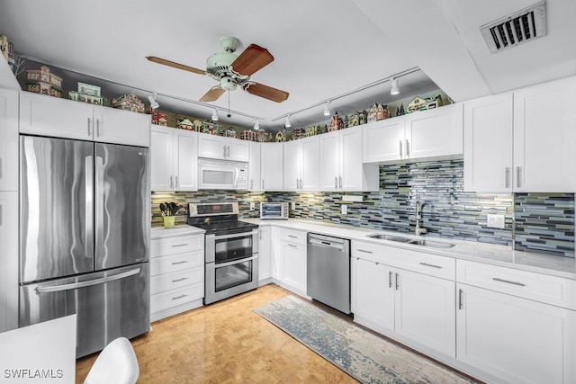 kitchen with sink, ceiling fan, white cabinetry, stainless steel appliances, and tasteful backsplash