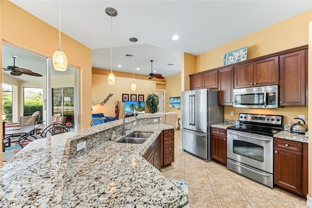 kitchen with ceiling fan, appliances with stainless steel finishes, decorative light fixtures, light stone countertops, and a sink