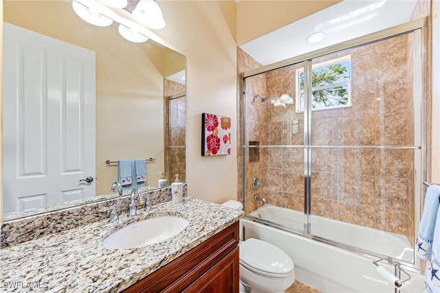 full bath with enclosed tub / shower combo, vanity, and toilet