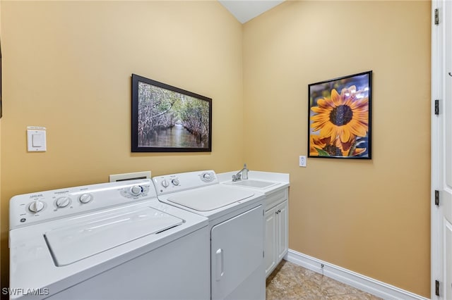 clothes washing area with cabinet space, baseboards, a sink, and washing machine and clothes dryer