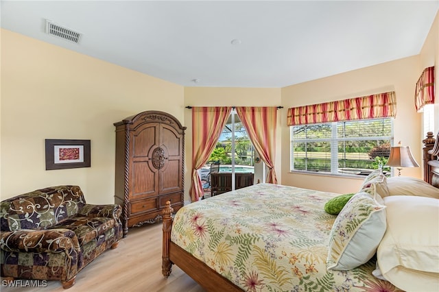 bedroom with access to exterior, light wood-type flooring, and visible vents