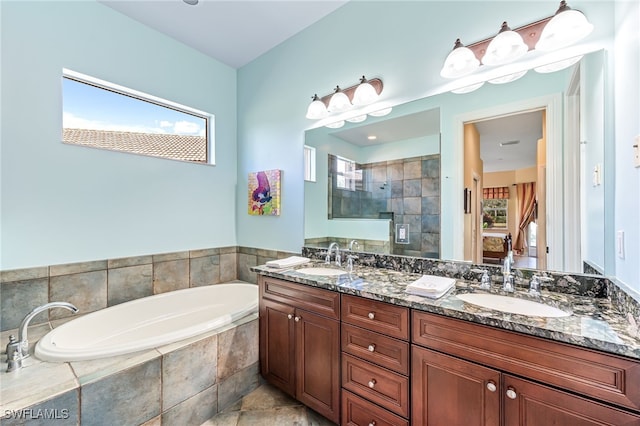 bathroom featuring a garden tub, double vanity, tiled shower, and a sink