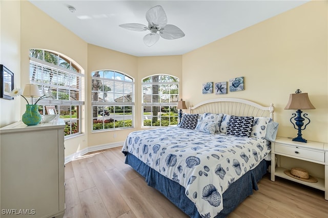 bedroom featuring baseboards, ceiling fan, and light wood finished floors