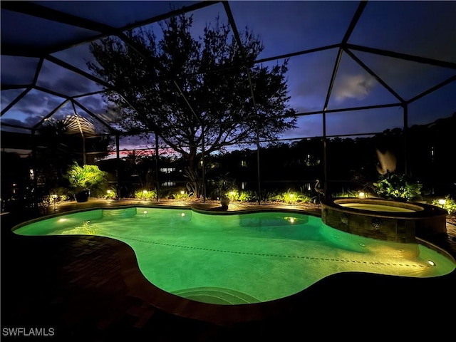 view of pool with glass enclosure, a pool with connected hot tub, and a patio area