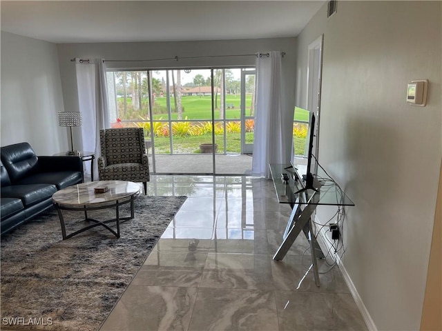 living area with visible vents, plenty of natural light, marble finish floor, and baseboards