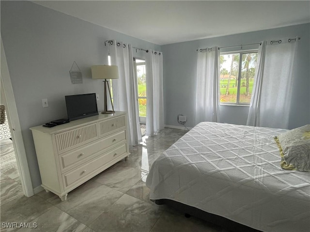 bedroom featuring multiple windows, baseboards, and marble finish floor