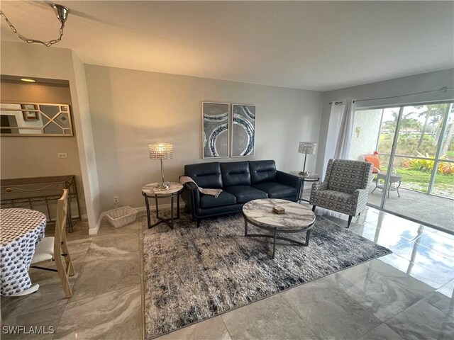 living area featuring baseboards and marble finish floor