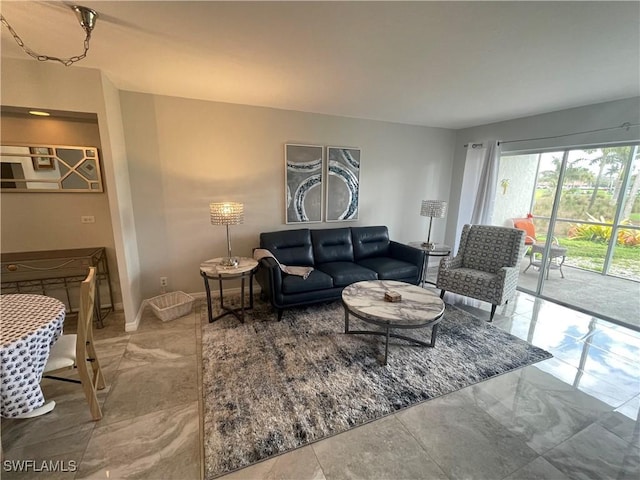 living area with baseboards and marble finish floor