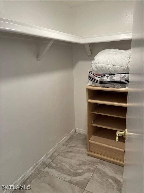 walk in closet with marble finish floor