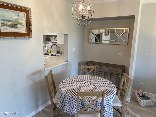 dining room featuring a notable chandelier and baseboards