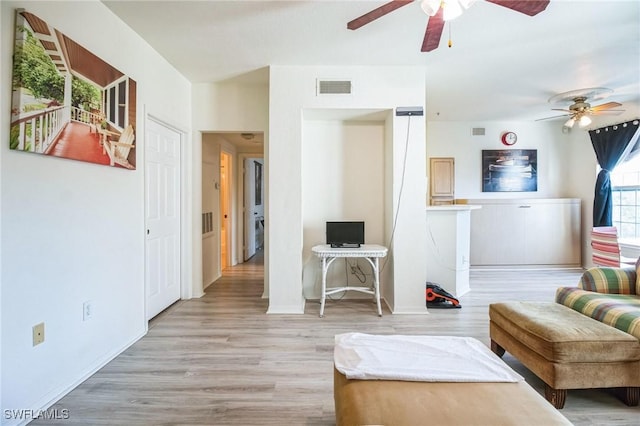 living room with light hardwood / wood-style flooring and ceiling fan