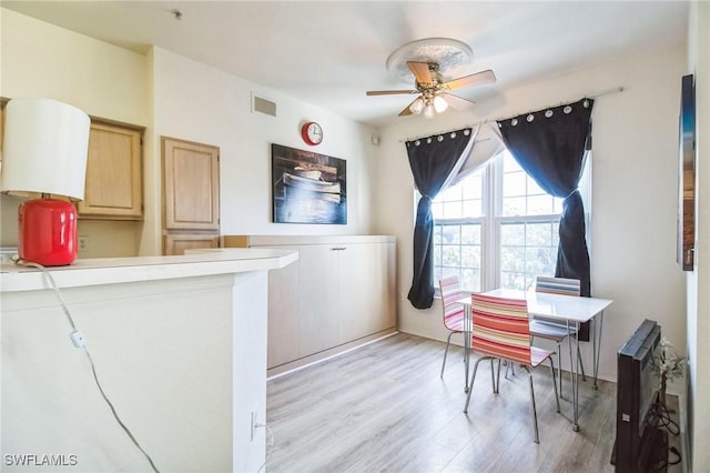 home office with ceiling fan and light hardwood / wood-style flooring