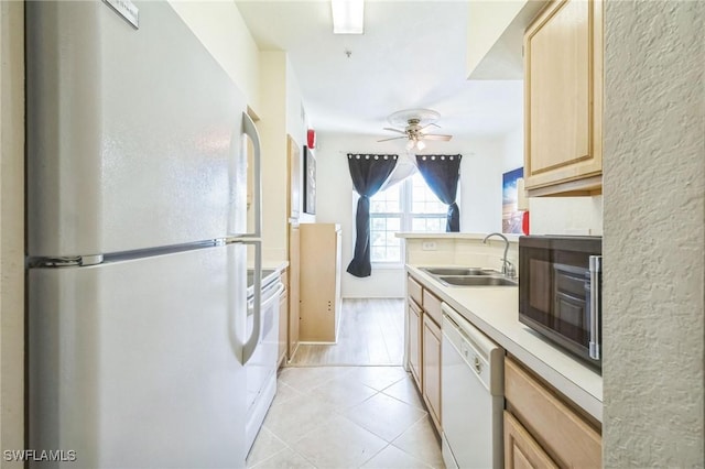 kitchen with sink, white appliances, light tile patterned floors, light brown cabinets, and ceiling fan