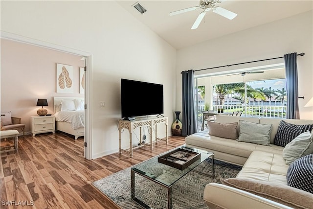 living room with wood finished floors, baseboards, visible vents, high vaulted ceiling, and ceiling fan