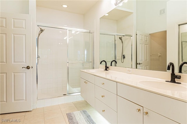 bathroom with a sink, visible vents, a stall shower, and tile patterned floors