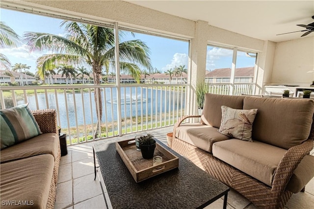 sunroom featuring a residential view, a water view, and ceiling fan