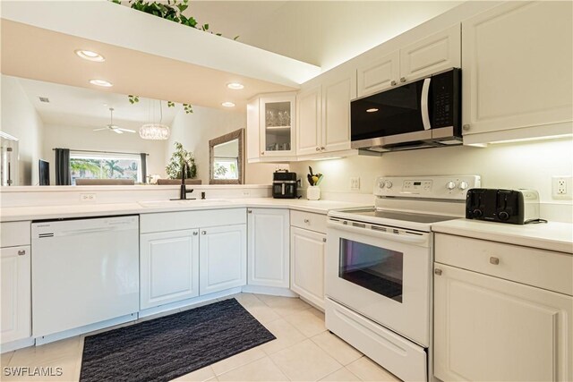 kitchen featuring white appliances, recessed lighting, a sink, light countertops, and glass insert cabinets