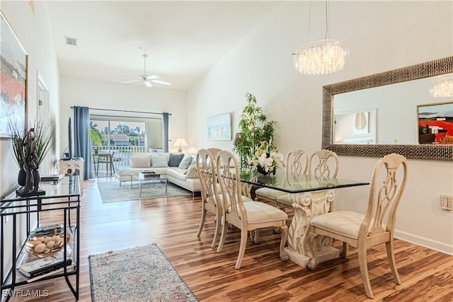 dining area featuring visible vents, high vaulted ceiling, and wood finished floors